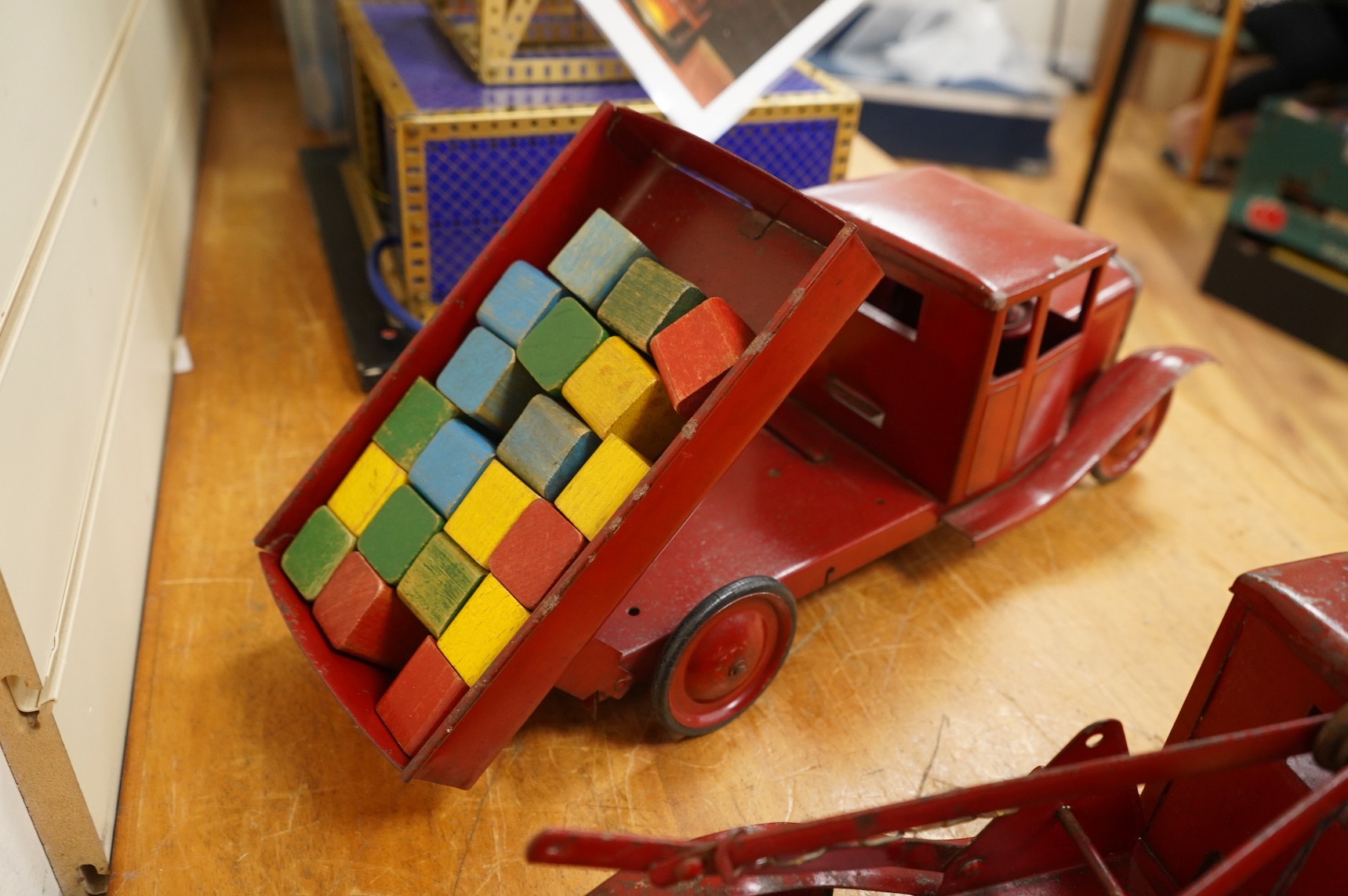 Two 1930's/40's Tri-ang large scale tinplate trucks, both with similar frames and cabs, one as a wreck truck with mounted crane, the other has a wagon with painted wooden blocks, each approximate 44cm long